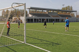 Nieuw kunstgras voetbalveld met de tribune Nieuw kunstgras voetbalveld met de tribune